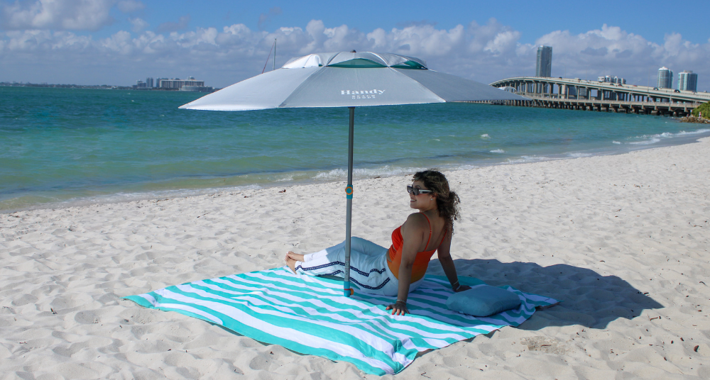 "Handy Beach Umbrella and Blanket set up perfectly by the water, offering a clean, private alternative to expensive resort chair rentals.