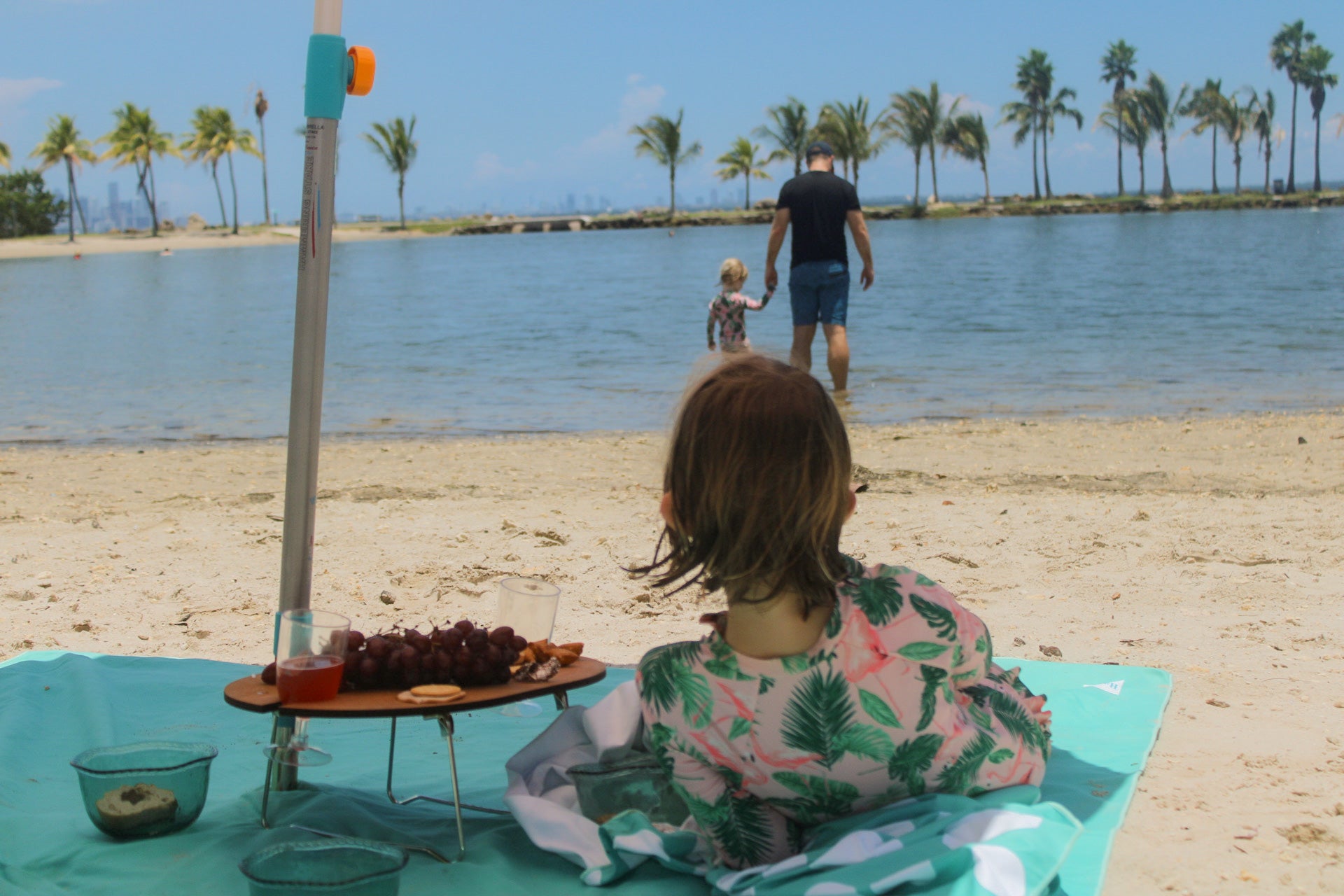 Lying under a an umbrella safely secured by a Handy Beach Anchor