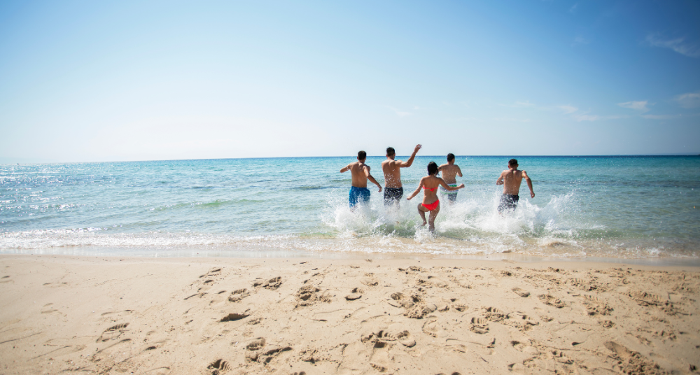 A sunny winter beach day in Florida with clear blue skies and a wind-resistant beach umbrella set up in the sand