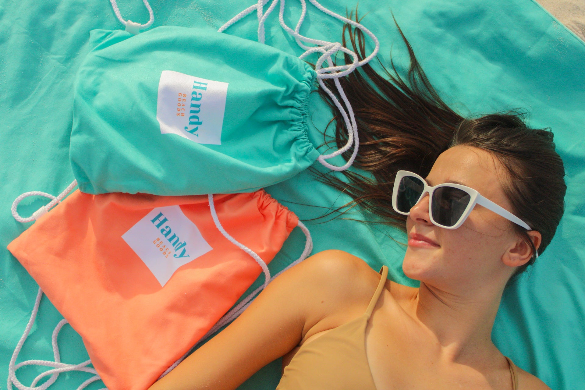 Lying on the Handy Beach Mat, the perfect accessory for beach relaxation