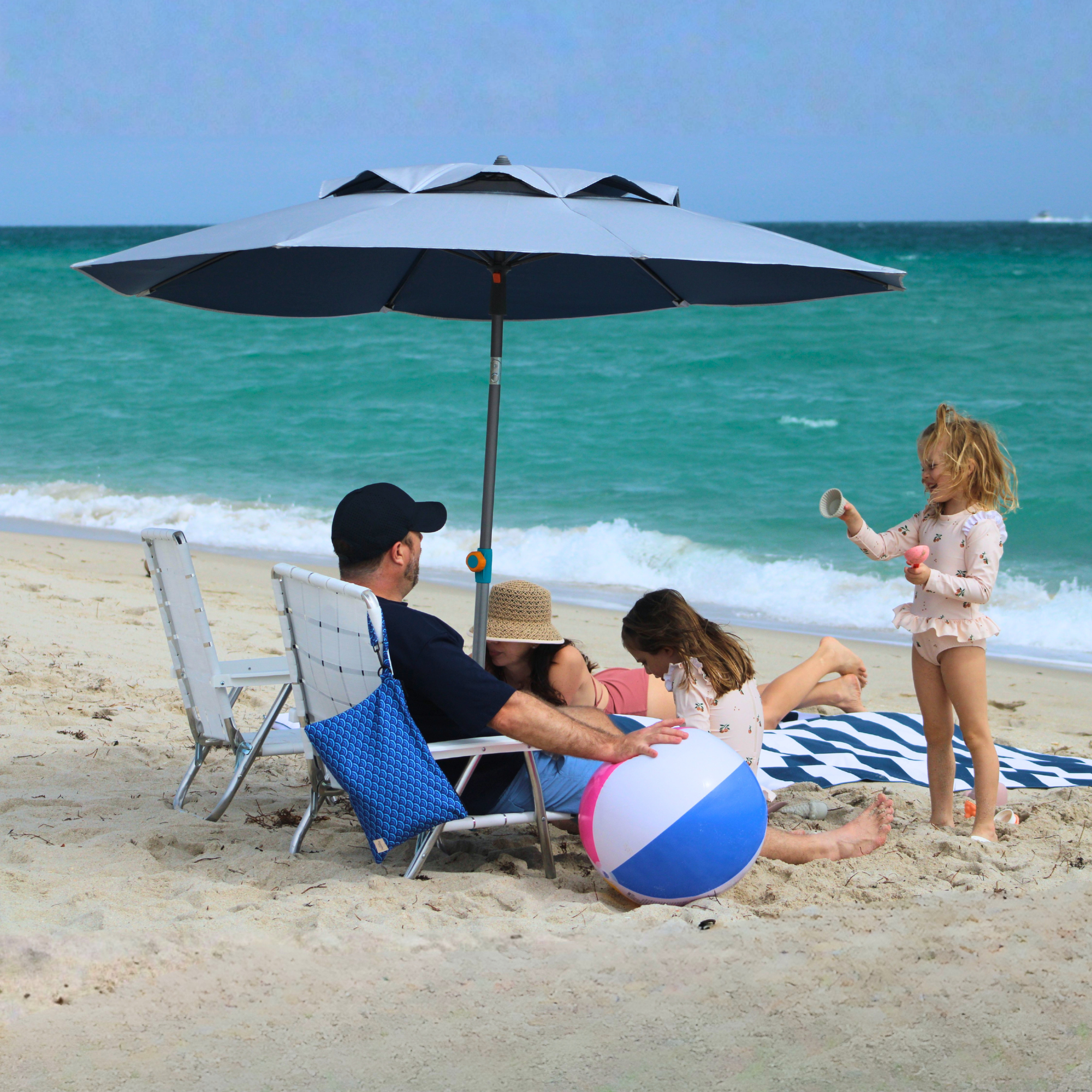 Family on a beach with a large umbrella 