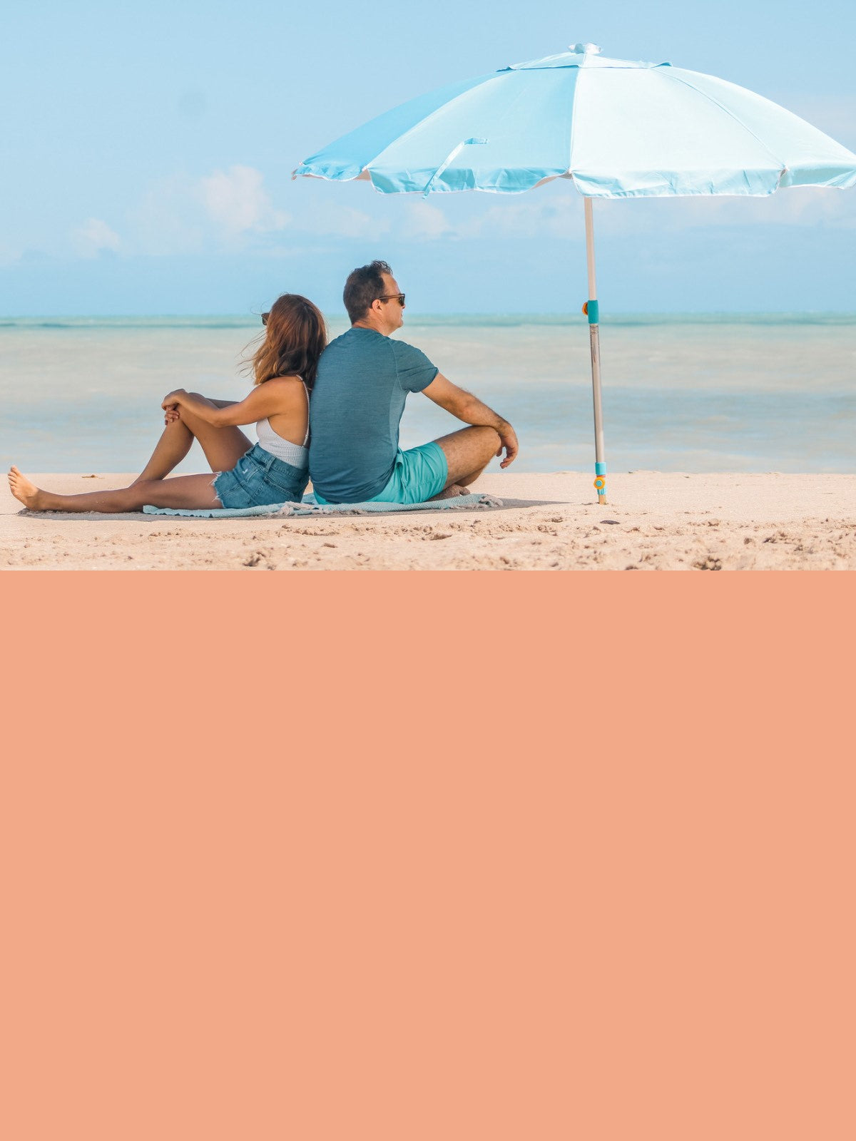 A couple enjoying beach life while using a Handy Beach Anchor and umbrella